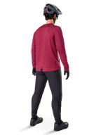 Alpinestars A-Dura Thermal Jersey, langärmeliges Radsport-Trikot in Burgunderrot, Rückansicht, getragen mit einer schwarzen Mountainbike-Hose und einem grauen Helm, mit verlängertem Rückenteil für zusätzlichen Schutz, Mountainbike-Ausrüstung für kaltes Wetter
