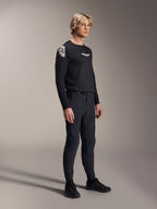Männliches Model in Alpinestars A-Aria Elite Hose in Black Titanium und Aria Polartec Elite LS Trikot, schwarze Mountainbike-Performance-Ausrüstung, mit laserperforierter Belüftung und Magnetverschluss an der Hose, langärmeliges Trikot mit weißen Logos, komplettes Offroad-Cycling-Outfit