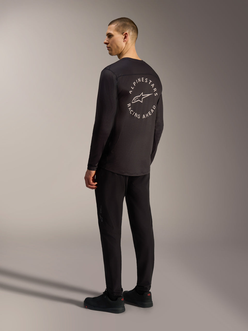 Schwarzes Alpinestars A-Dura Air Langarmtrikot mit weißer Racing Ahead Grafik auf dem Rücken, funktionaler MTB-Stil.