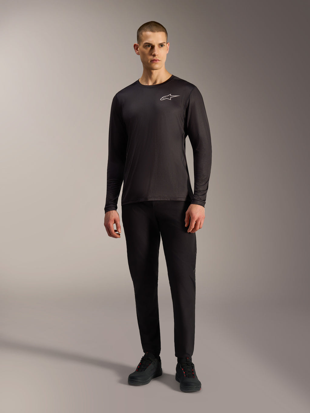 Schwarzes A-Dura Air Langarm-Trikot, feuchtigkeitsableitende MTB-Bekleidung mit weißem Alpinestars-Logo an einem Modell.