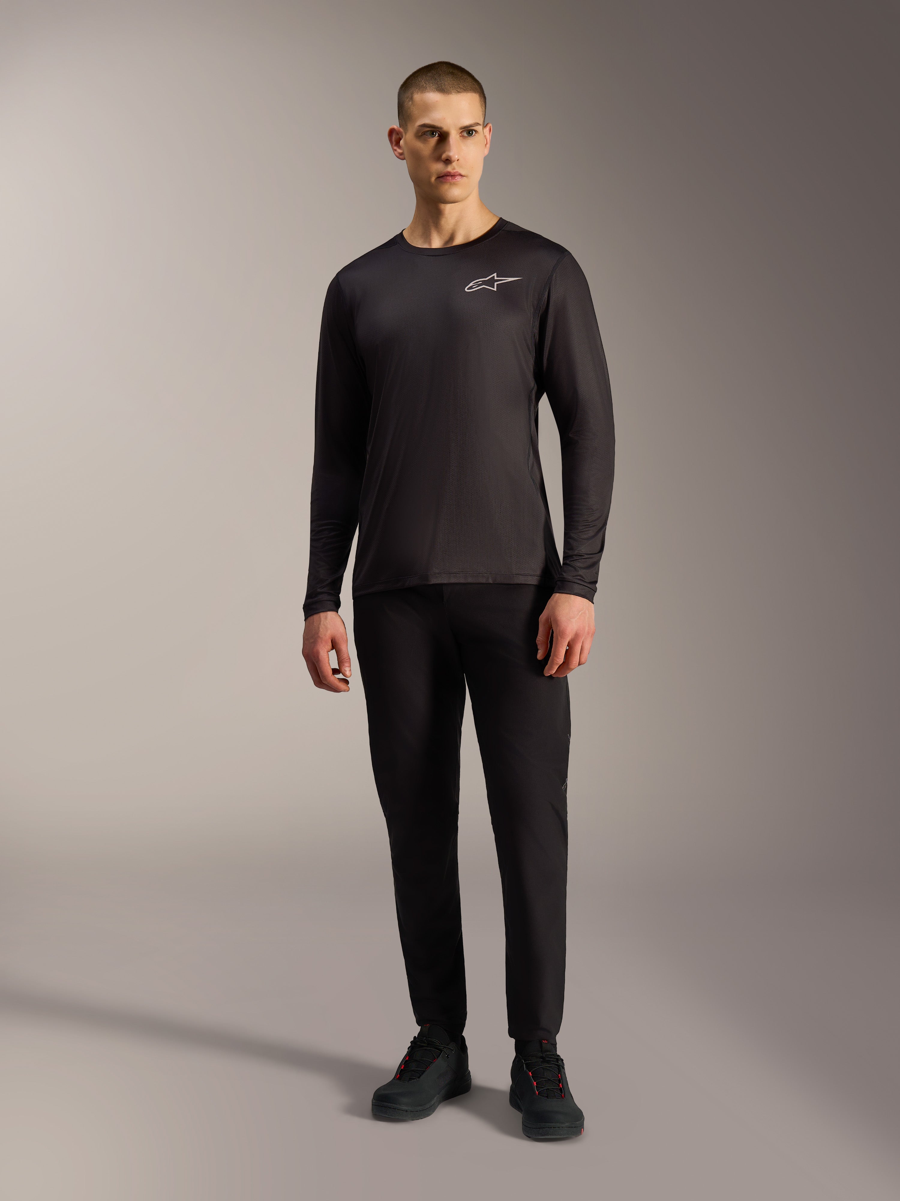 Schwarzes A-Dura Air Langarm-Trikot, feuchtigkeitsableitende MTB-Bekleidung mit weißem Alpinestars-Logo an einem Modell.