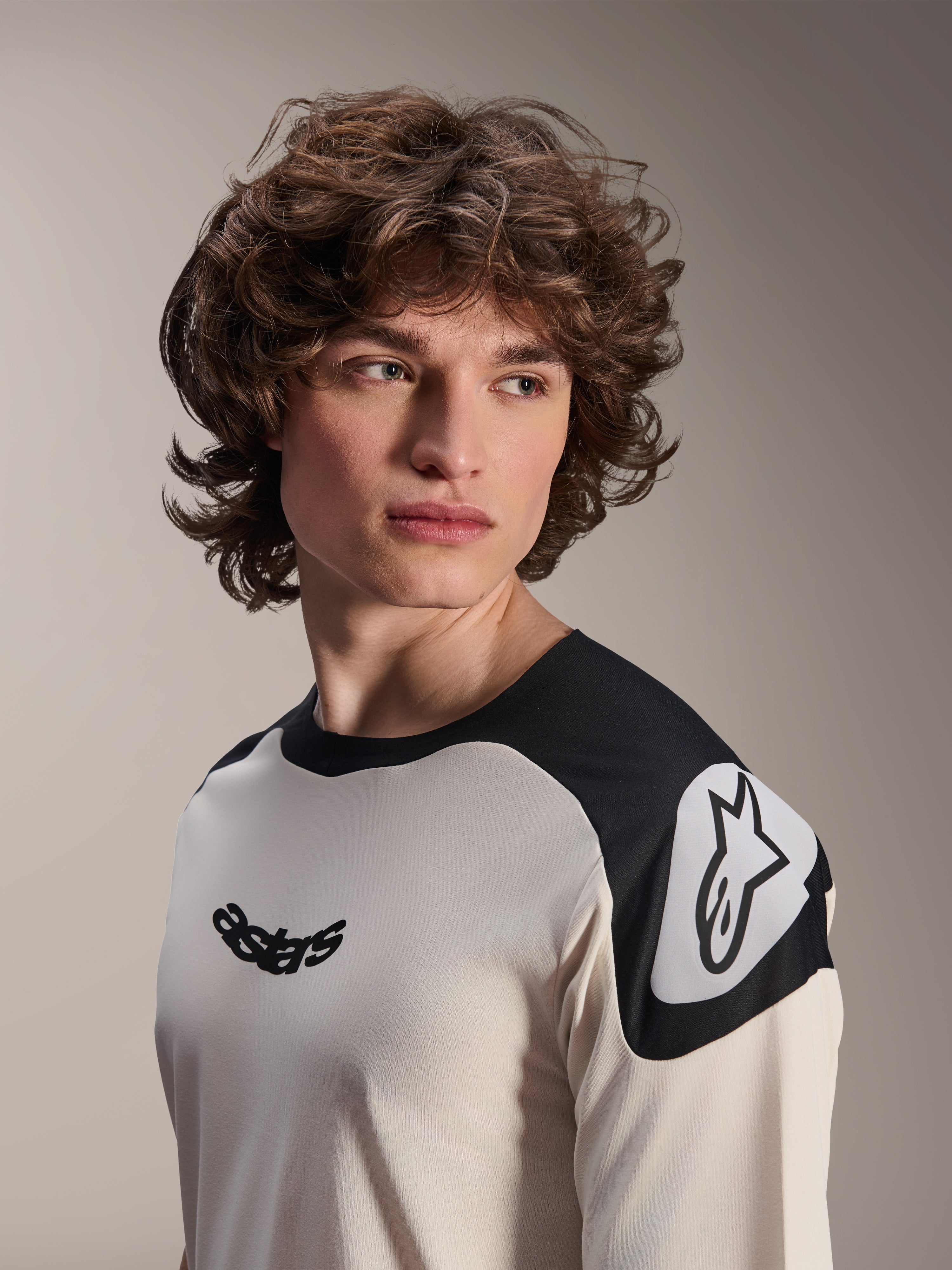 Alpinestars A-Aria Polartec Elite Kurzarm-Trikot, Ecru mit schwarzen Schultereinsätzen, mit schwarzem Astars-Logo auf der Brust und weißem Astars-Logo auf der Schulter, leistungsstarke Mountainbike-Bekleidung, getragen von einem Modell