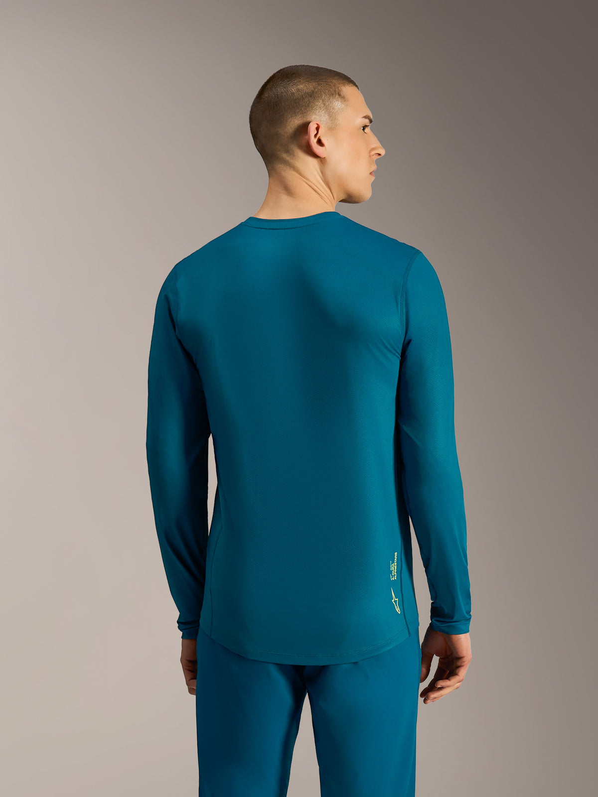 Alpinestars A-Dura Ride Langarm-Trikot in Blau-Grün, mit verlängertem Rücken und Logo für MTB-Performance.