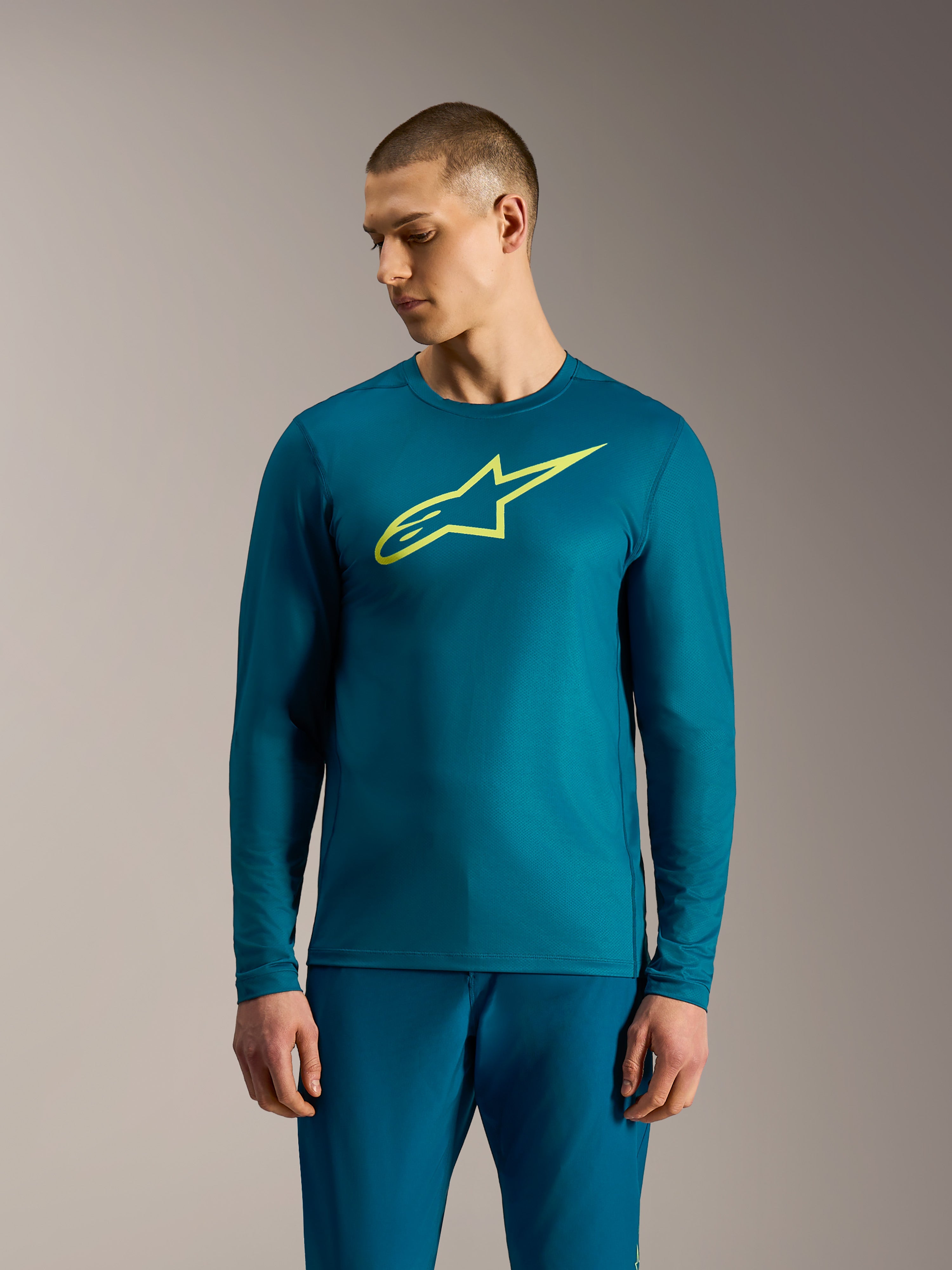 Blau-grünes A-Dura Ride Langarmtrikot mit neongelbem Alpinestars-Logo, funktionale Mountainbike-Bekleidung.