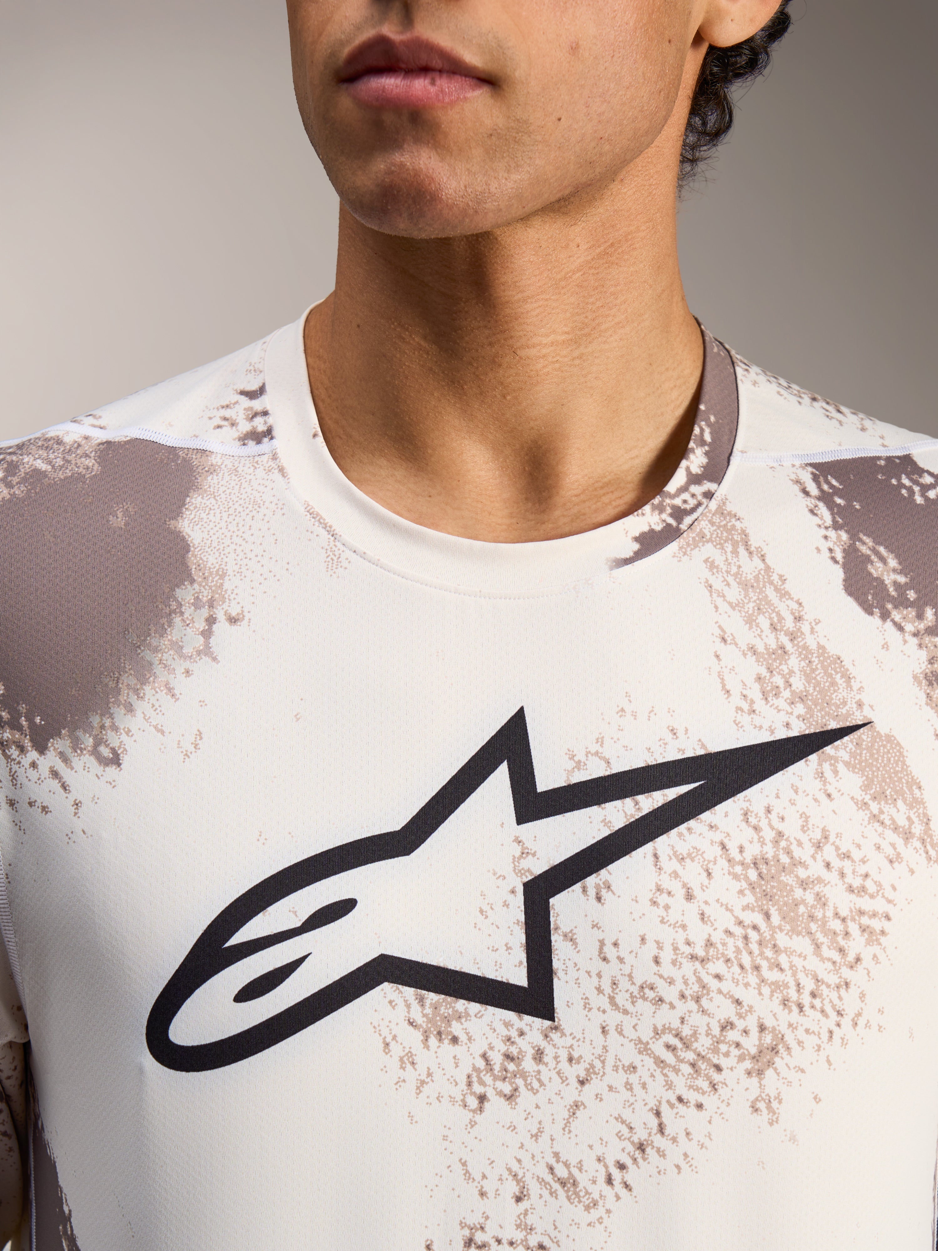A-Dura Ride Langarmtrikot in Sand Camo mit zentralem schwarzen Alpinestars-Logo und Rundhalsausschnitt.