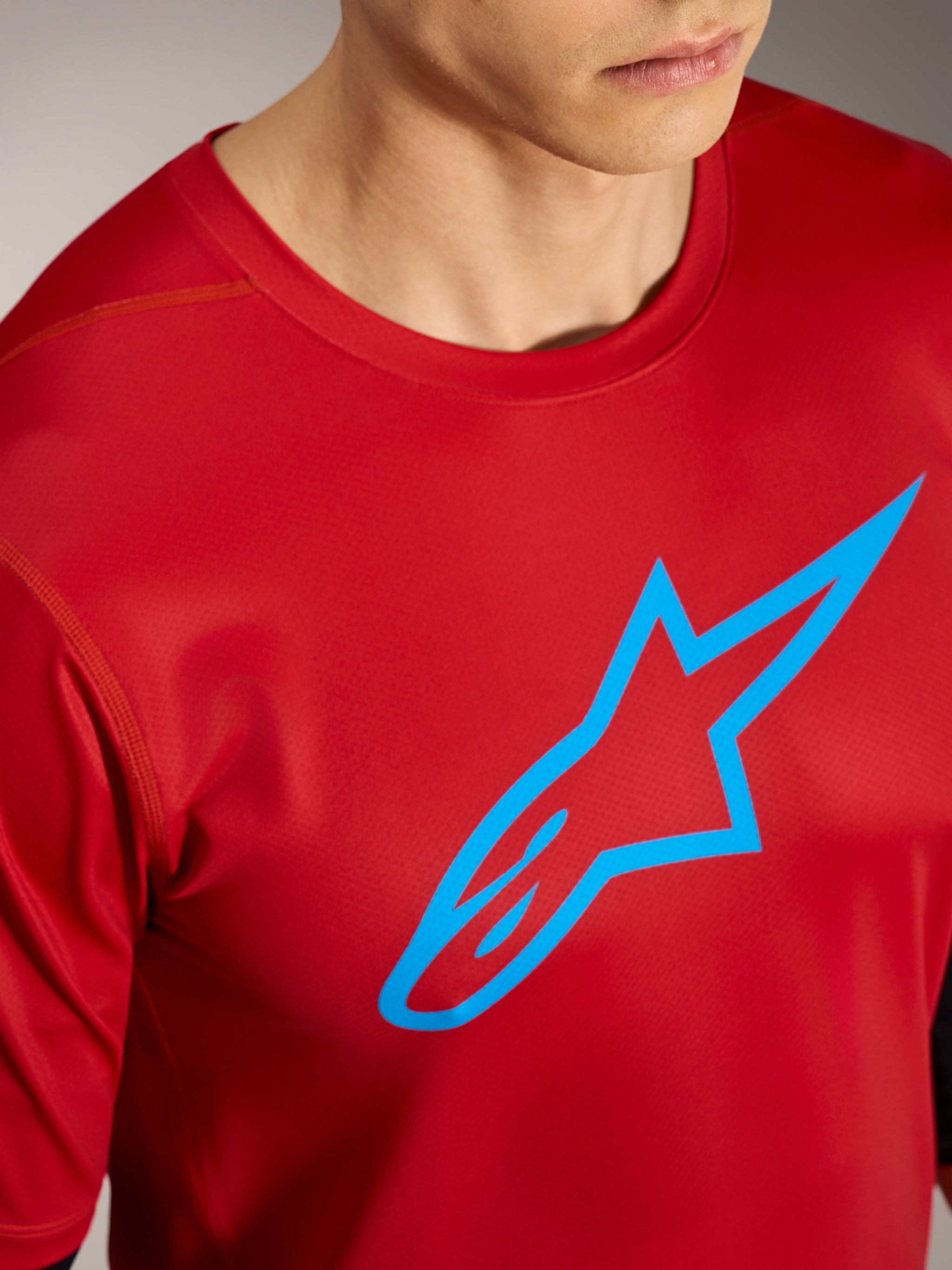 Rotes A-Dura Ride Kurzarmtrikot mit blauem Alpinestars-Logo, leistungsstarke Mountainbike-Bekleidung.