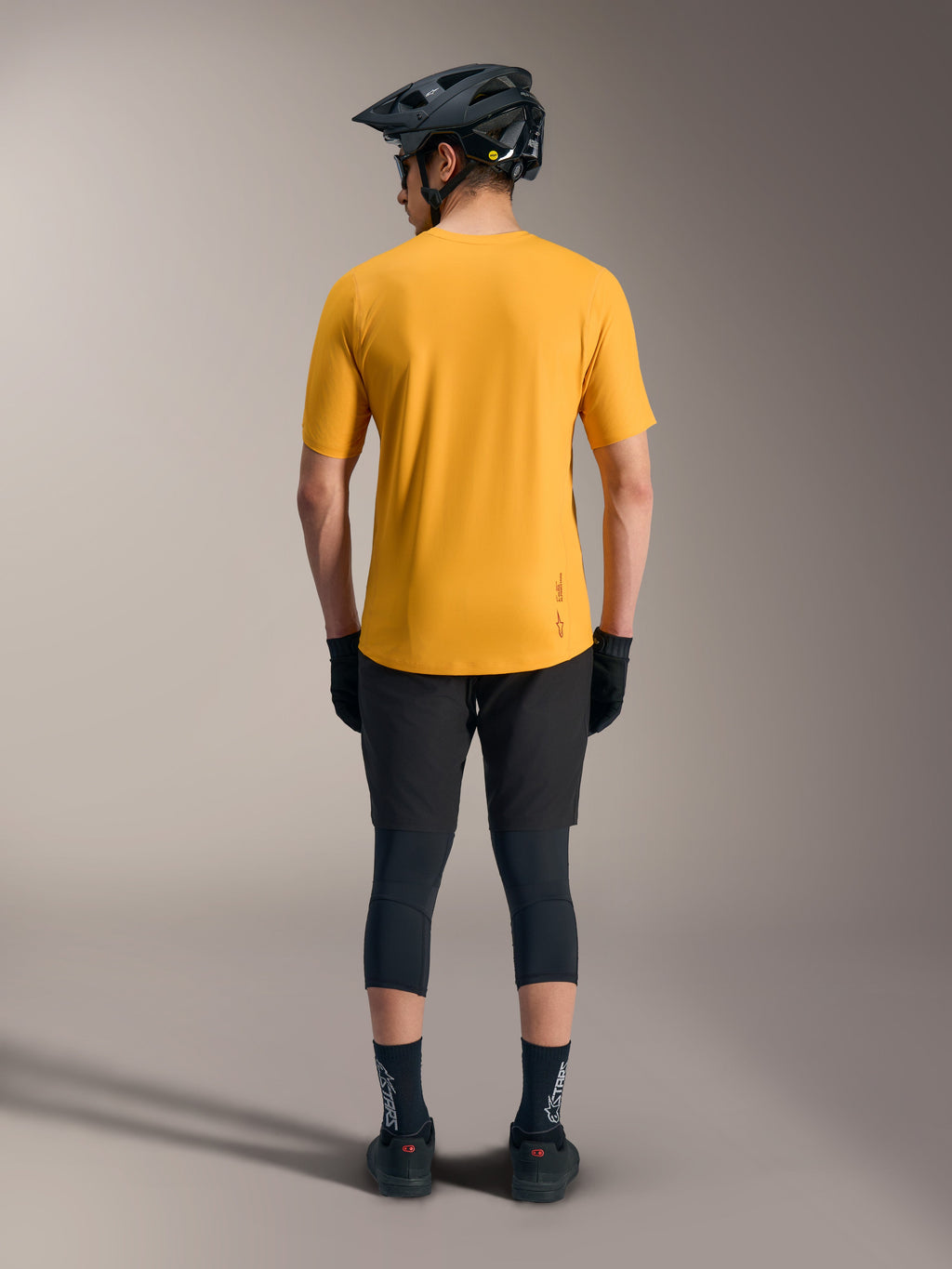 Oranges A-Dura Ride Kurzarmtrikot, Rückansicht mit verlängertem Rücken und Logo-Detail, lässiger Mountainbike-Stil.