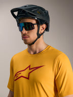Oranges A-Dura Ride Kurzarmtrikot mit rotem Astars-Logo, schwarzem MTB-Helm und Performance-Sonnenbrille.