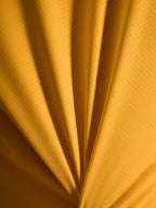 Orangefarbene Textur des A-Dura Ride Trikots aus leichtem Jacquard-Poly-Spandex-Material in der Detailansicht.