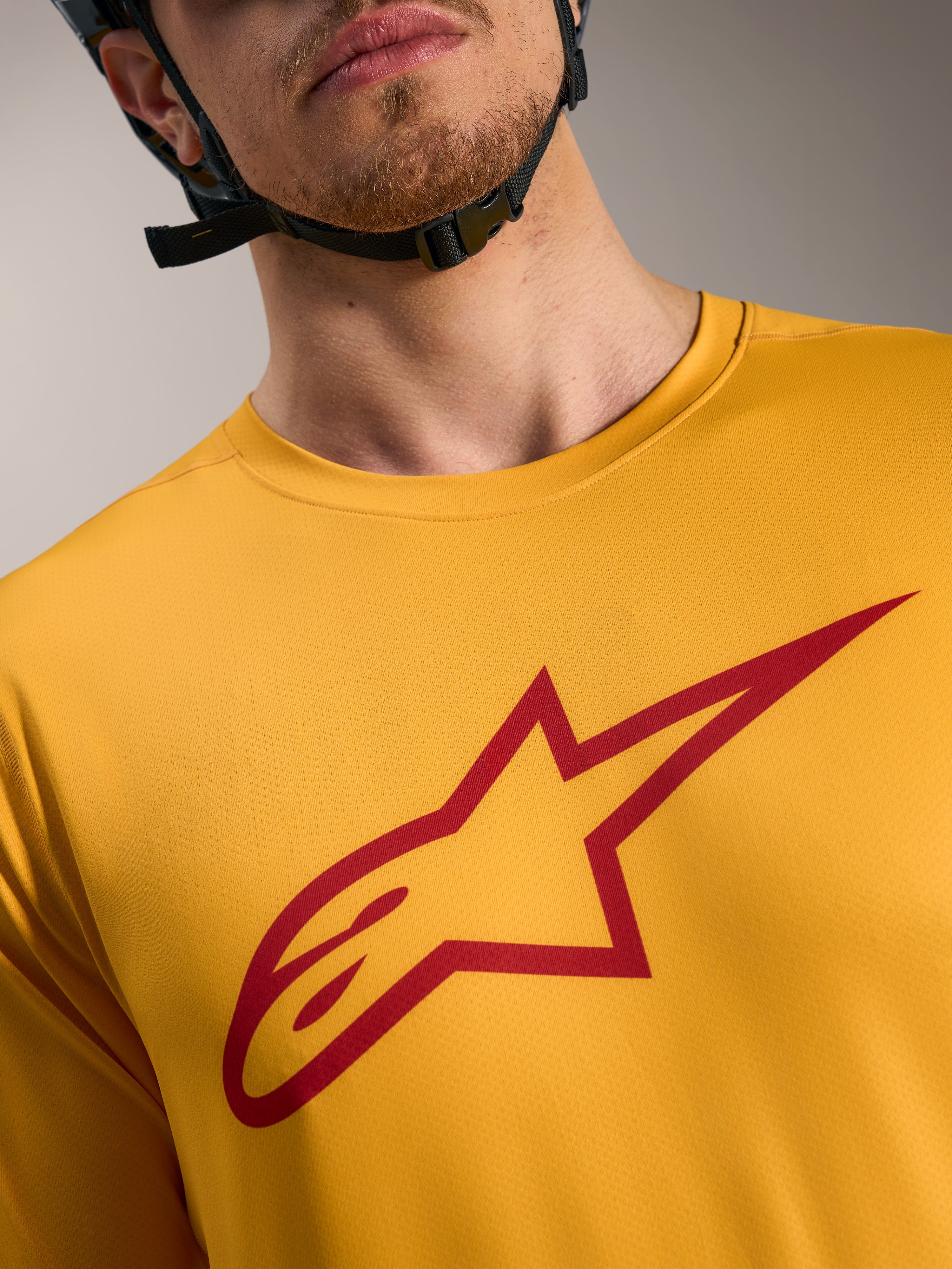 Oranges A-Dura Ride Kurzarmtrikot mit rotem Astars-Logo auf der Brust, leichte MTB-Performance-Bekleidung.