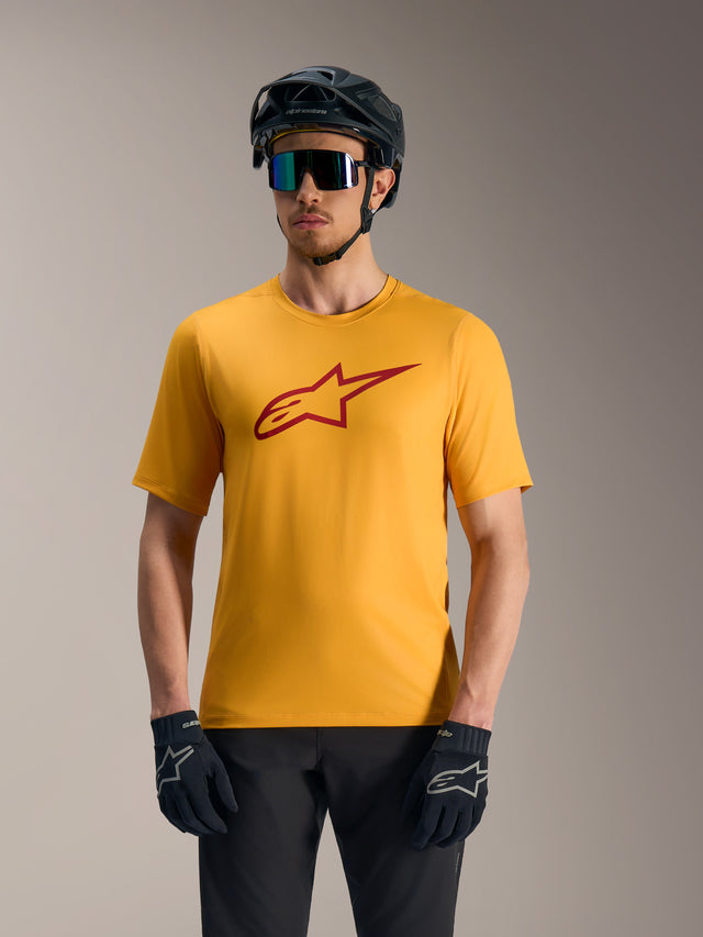Oranges A-Dura Ride Kurzarmtrikot mit rotem Astars-Logo, kombiniert mit MTB-Helm und Handschuhen.