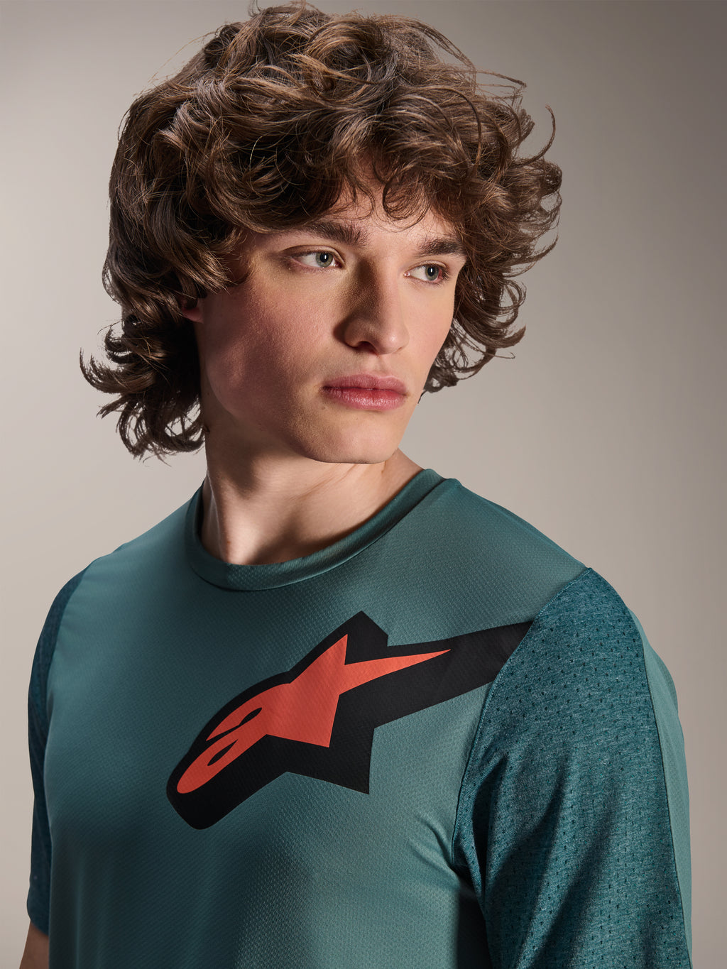 Alpinestars A-Dura Lipan Trikot, Kurzarm-MTB-Trikot, Silver Pine, mit markantem rot-schwarzem Astars-Logo auf der Brust, strukturierten Jacquard-Ärmeln, Porträtaufnahme eines Models in Performance-Radsportbekleidung