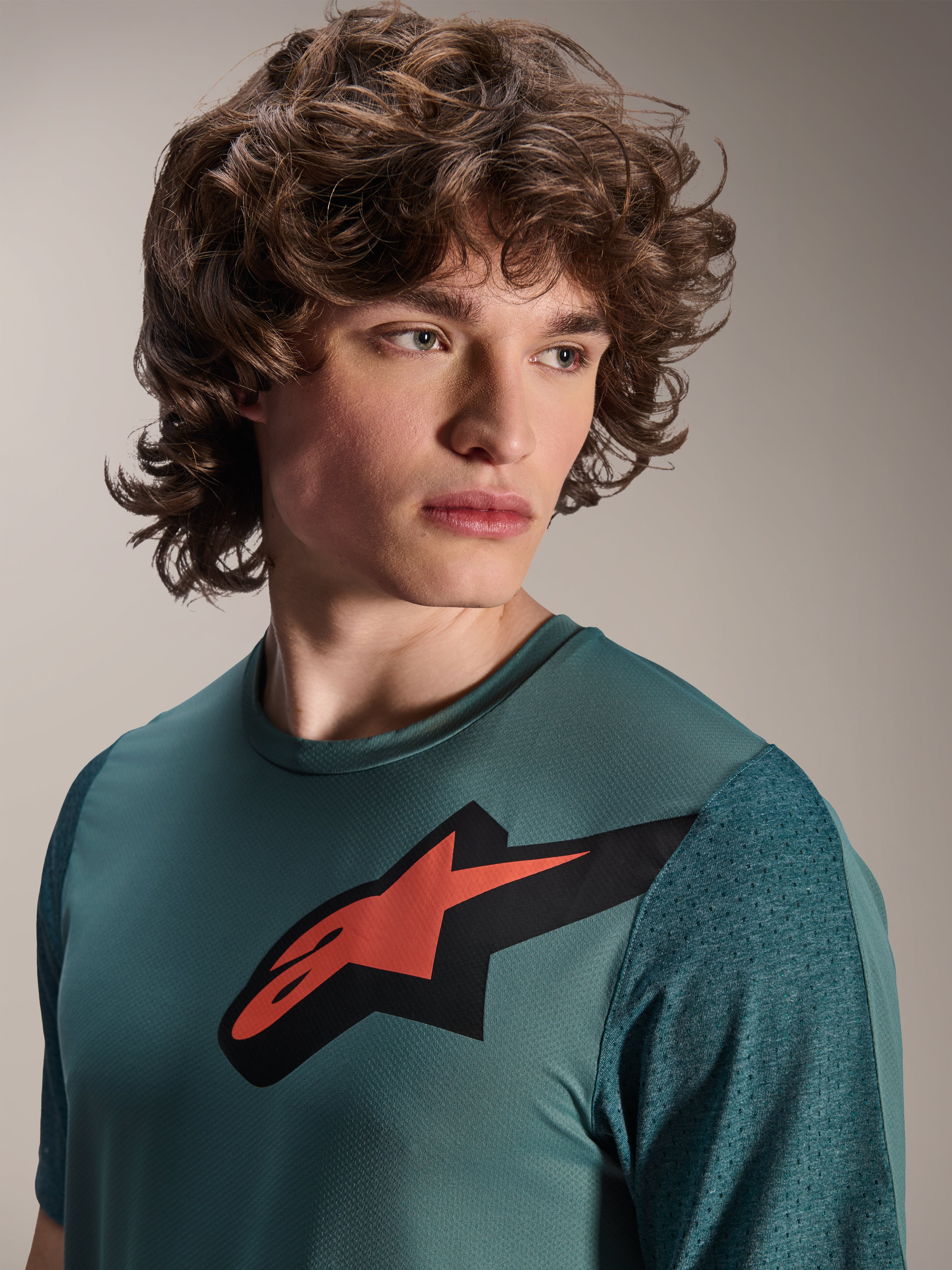 Alpinestars A-Dura Lipan Trikot, Kurzarm-MTB-Trikot, Silver Pine, mit markantem rot-schwarzem Astars-Logo auf der Brust, strukturierten Jacquard-Ärmeln, Porträtaufnahme eines Models in Performance-Radsportbekleidung
