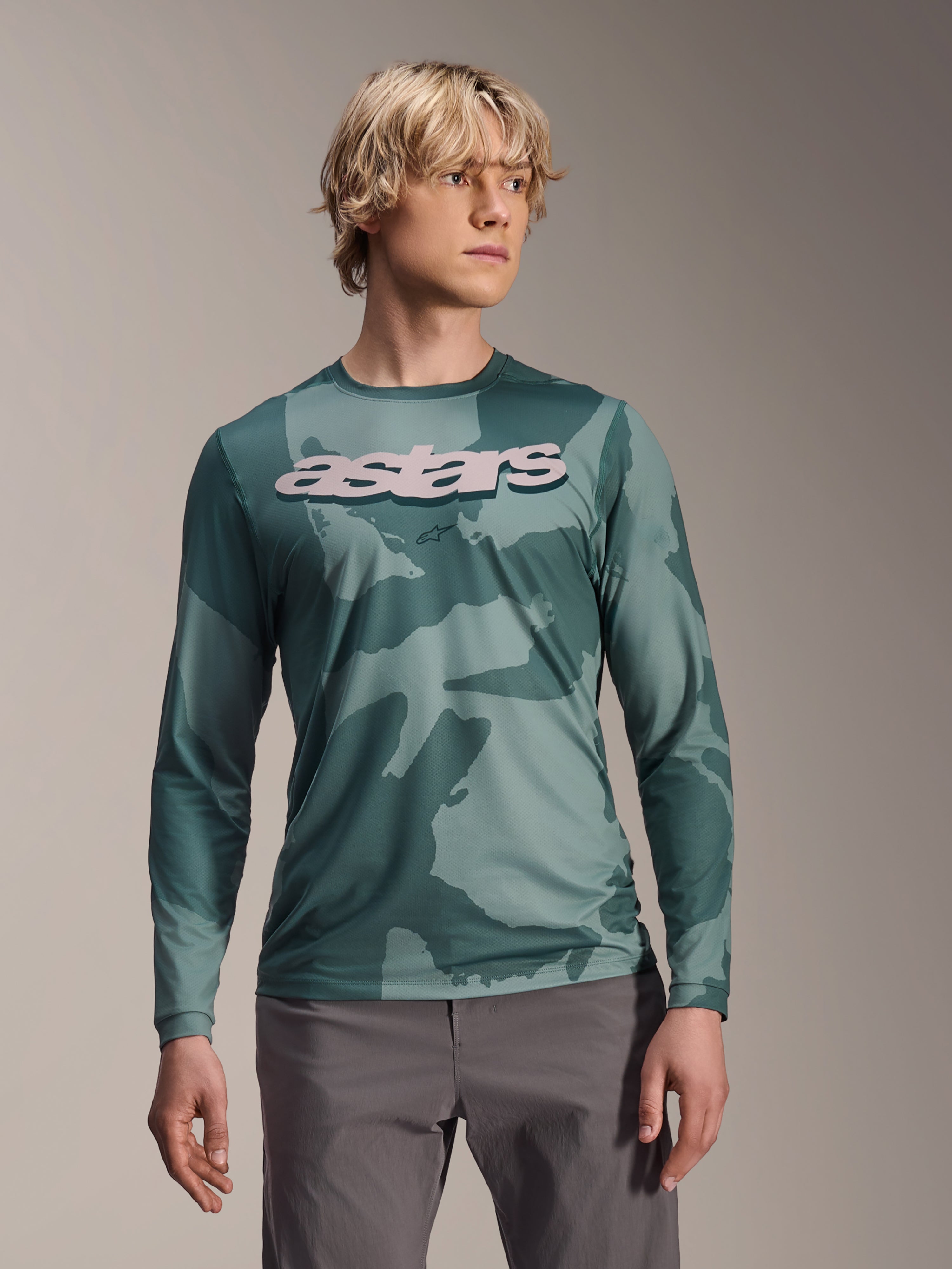 Alpinestars A-Dura Hollow Camo Langarmtrikot, MTB-Jersey, Silver Pine Camo grünes Tarnmuster, großes hellgraues astars-Logo auf der Brust, kombiniert mit grauer Hose, leistungsstarke Mountainbike-Bekleidung