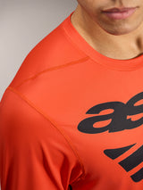 Oranges A-Dura ASTARS Langarmtrikot 2.0 mit schwarzem Logo und atmungsaktivem, strukturiertem Funktionsgewebe.