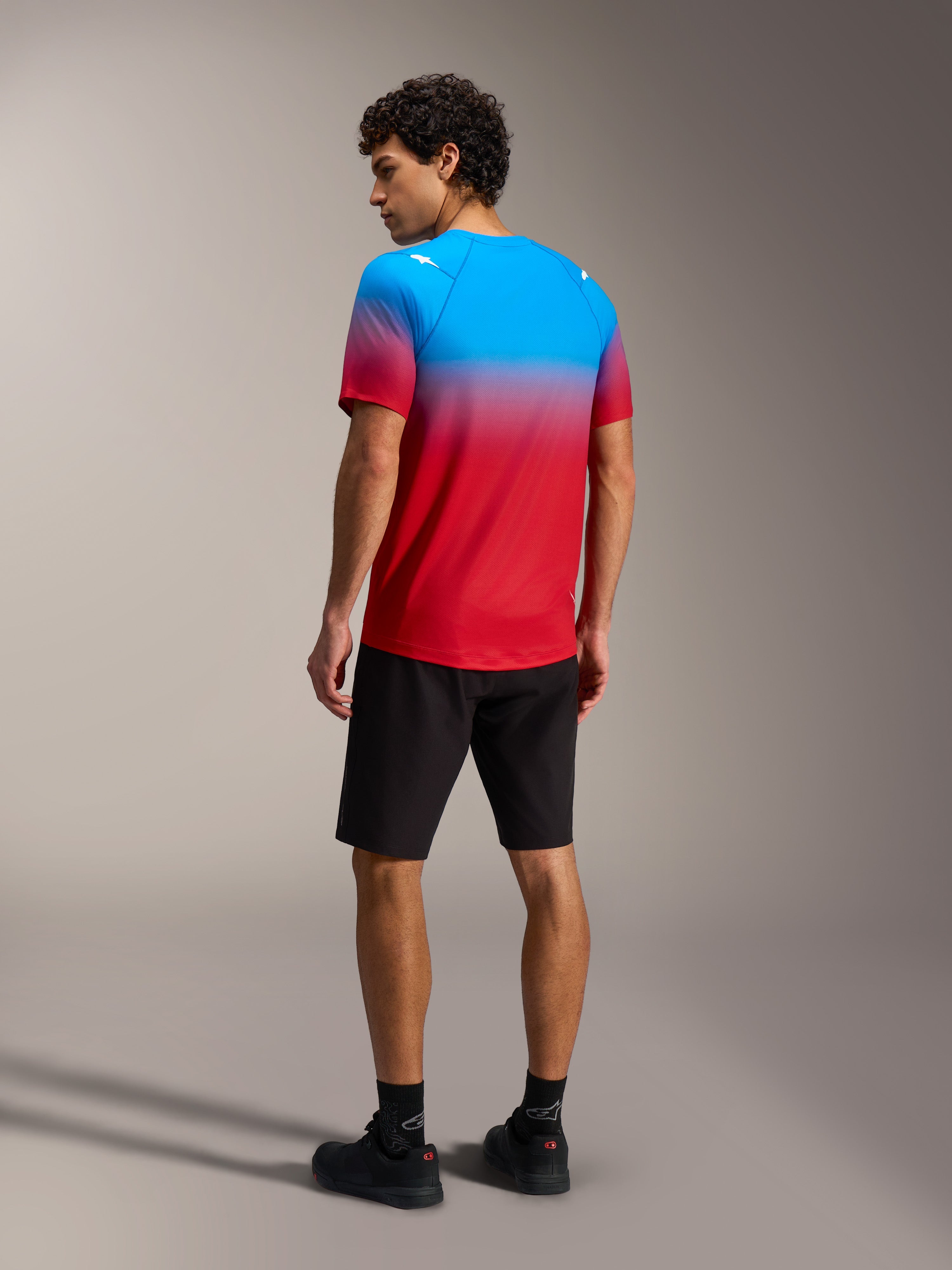 A-Dura ASTARS 2.0 Kurzarmtrikot, rot-blauer Farbverlauf, Rückansicht am Modell, Performance-Mountainbike-Ausrüstung.