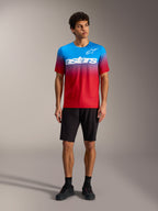A-Dura ASTARS Jersey 2.0 in Hellrot-Blau mit weißem Logo, kombiniert mit schwarzen MTB-Shorts und Schuhen.