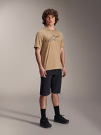 Männliches Model in schwarzen Alpinestars A-Dura Liner Shorts, kombiniert mit einem beigefarbenen A-Dura SS Jersey mit grauem Astars-Logo, schwarzen Fahrradsocken und Mountainbike-Schuhen, komplettes Offroad-Fahrrad-Outfit