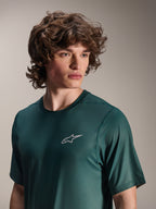 Alpinestars A-Dura Rise Kurzarmtrikot, Silver Pine Grün, von einem Modell getragen, kleines weißes Astars-Logo auf der Brust, Jacquard-Performance-Gewebe, lässige Mountainbike-Bekleidung