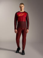 Alpinestars A-Dura Elite 2.0 Langarmtrikot in Bordeaux mit gelbem Logo und roten Bruststreifen.
