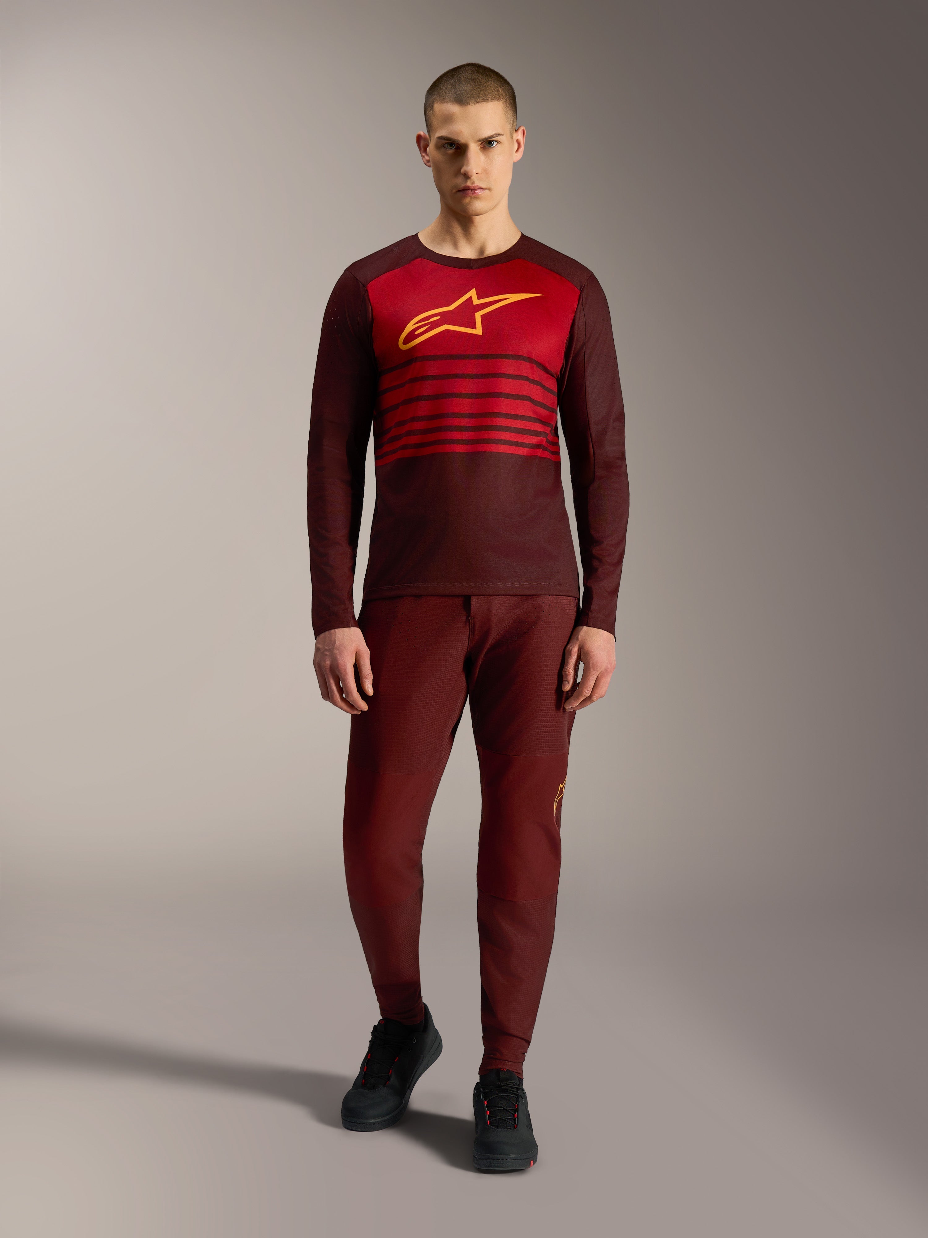 Alpinestars A-Dura Elite 2.0 Langarmtrikot in Bordeaux mit gelbem Logo und roten Bruststreifen.