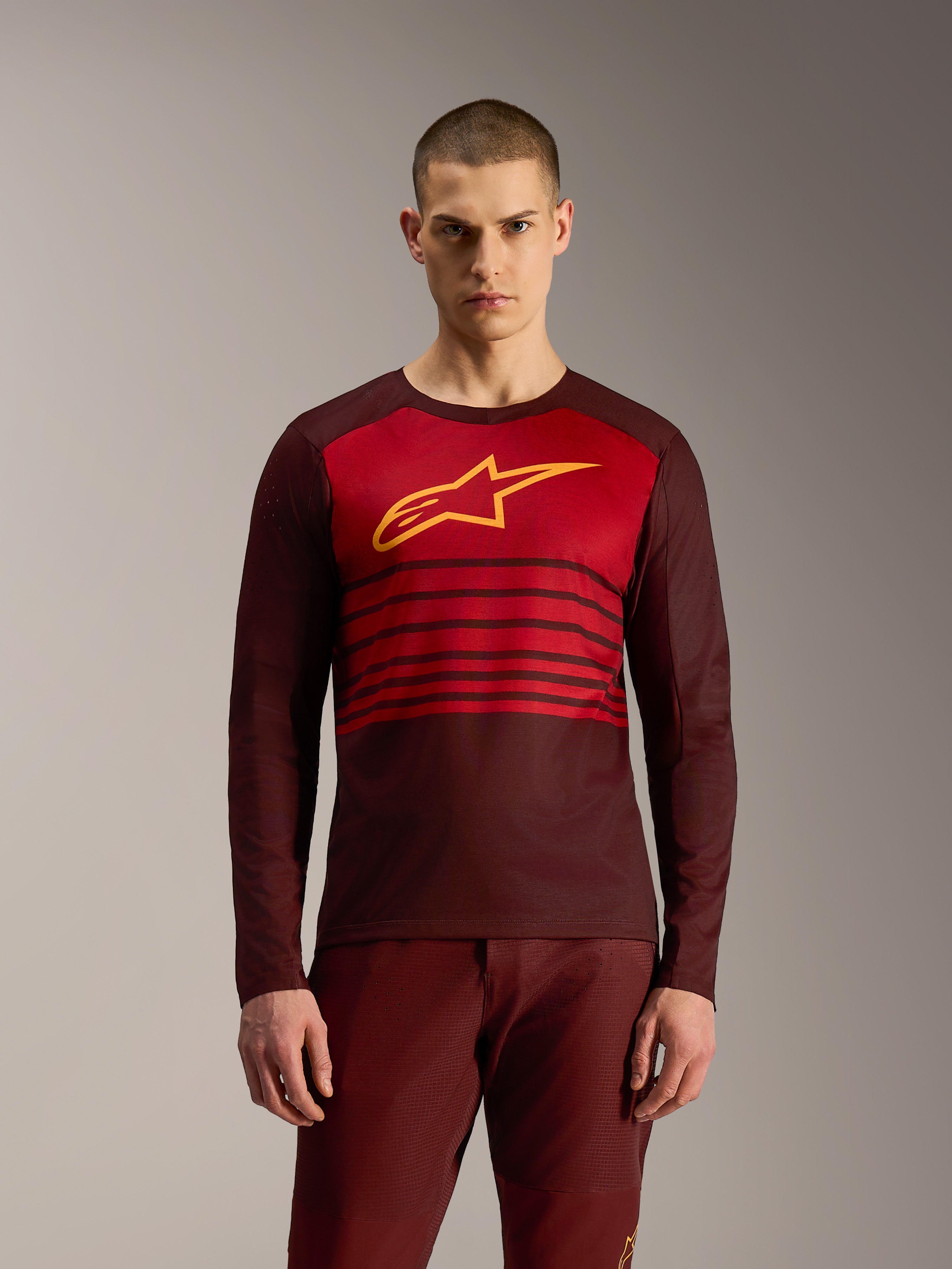 Bordeauxrotes A-Dura Elite Langarmtrikot 2.0 mit horizontalen Streifen und gelbem Alpinestars-Logo für MTB-Fahrten.