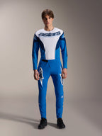 Alpinestars A-Supra Melt Hose, blaue MTB-Hose, getragen mit passendem weiß-blauem Langarmtrikot, weiße Stern-Logos auf den Oberschenkeln, schmale Performance-Passform für Offroad-Radsport