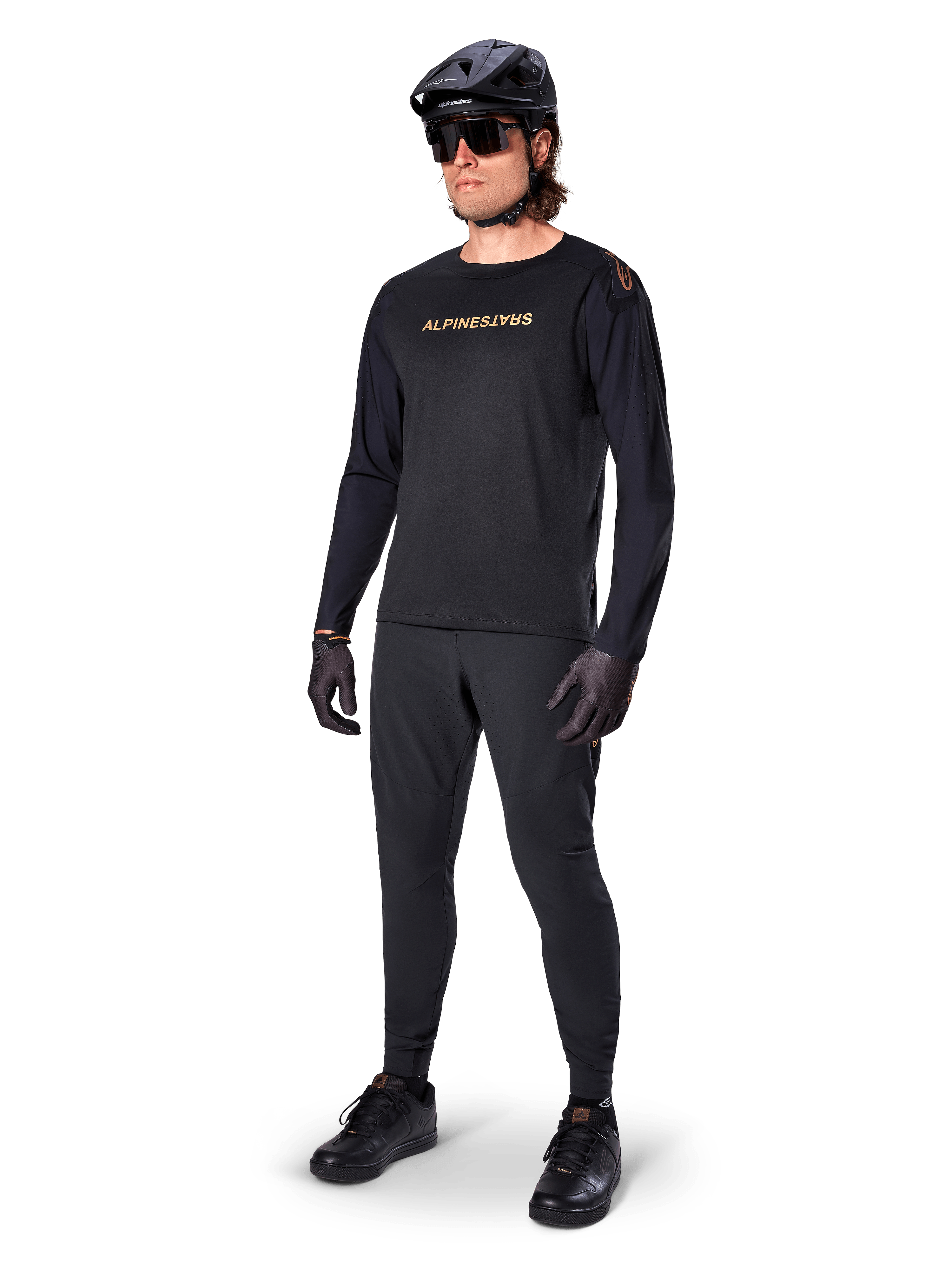 Alpinestars A-Aria Polartec Switch Long Sleeve Jersey, Black, bronze branding on chest, worn by mountain biker with black helmet and sunglasses, performance cycling apparel for trail riding