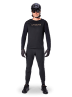 Alpinestars A-Aria Polartec Switch Long Sleeve Jersey, Black, worn by a rider with matching black technical pants, black helmet, sunglasses, and black gloves, performance MTB gear for off-road trails