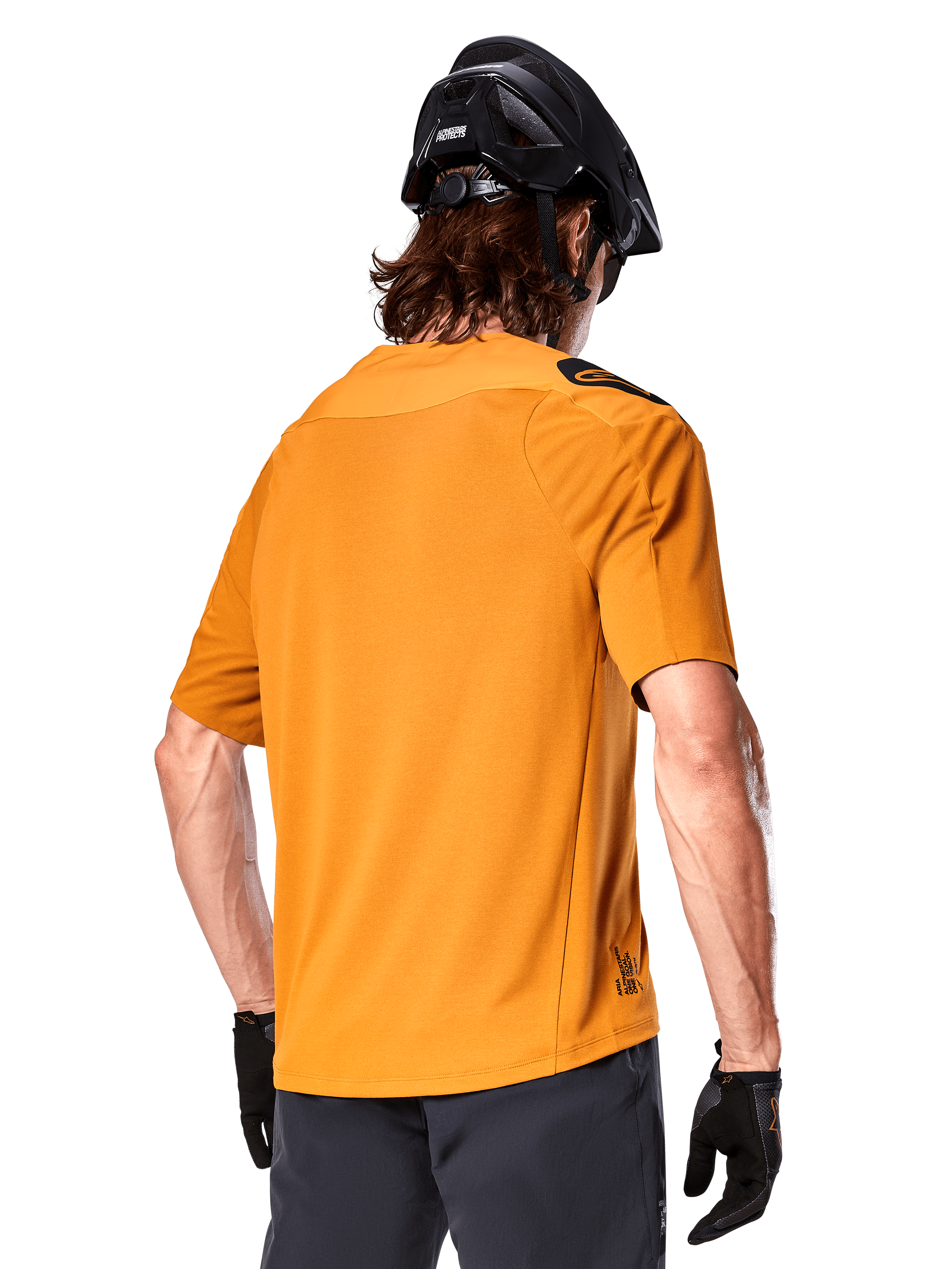 Alpinestars A-Aria Polartec Switch Trikot, Kurzarm-MTB-Trikot, Dunkelgold, Rückansicht mit Performance-Passform, getragen mit schwarzem Helm und grauen Shorts, strapazierfähige und atmungsaktive Trail-Bekleidung