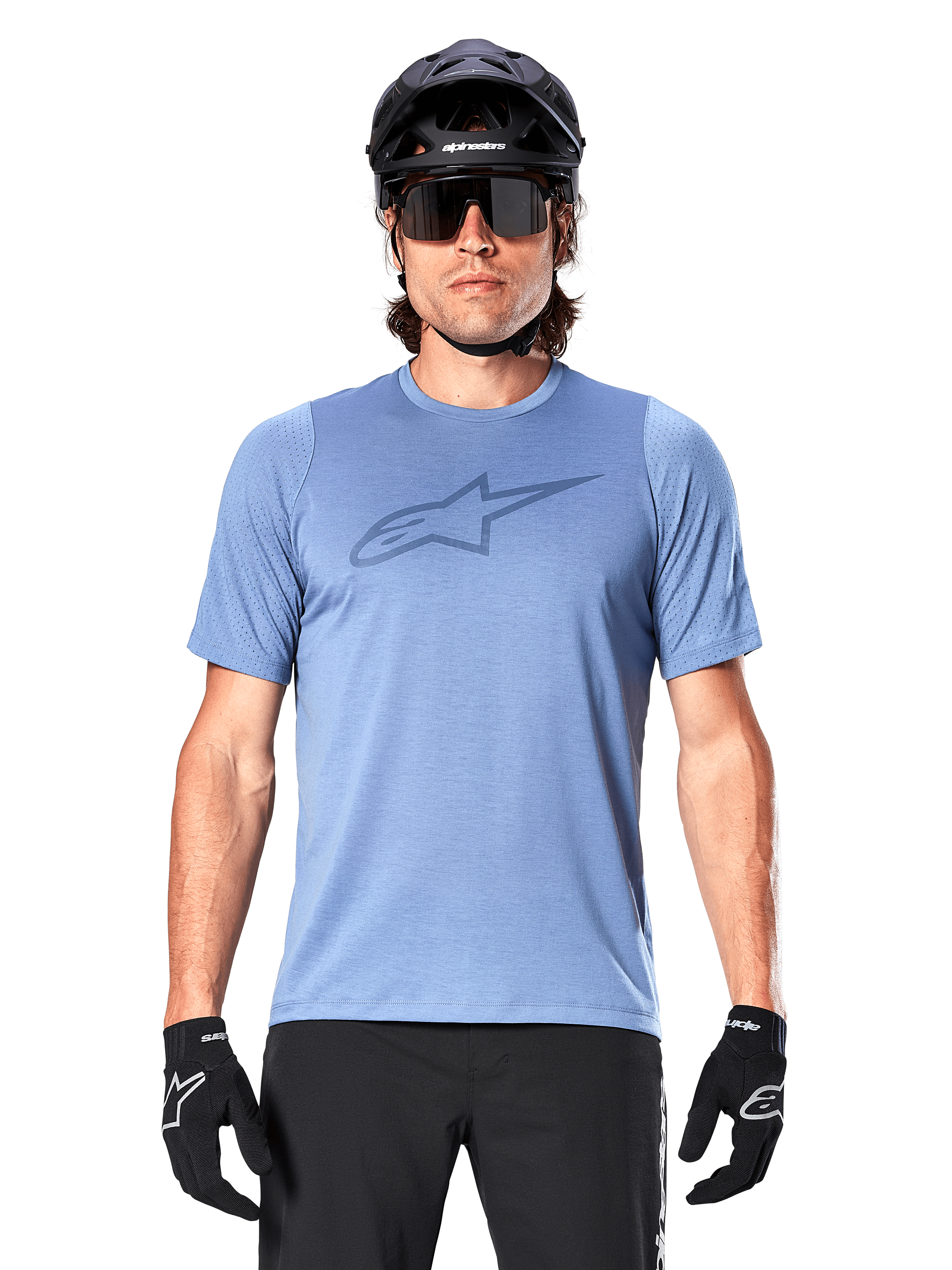 Männlicher Mountainbiker im Alpinestars A-Dura Dri Astar Kurzarmtrikot in Infinity Blue, mit dezentem Brustlogo und Mesh-Einsätzen, kombiniert mit einem schwarzen Helm, einer Sonnenbrille und schwarzen Handschuhen für ein technisches Radsport-Outfit