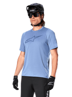 Alpinestars A-Dura Dri Astar Kurzarmtrikot, Infinity Blue, Mountainbike-Trikot mit Mesh-Ärmelbelüftung und großem Brustlogo, kombiniert mit schwarzem Helm, Sonnenbrille und Handschuhen, technische MTB-Performance-Bekleidung