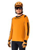 Alpinestars A-Dura Dri Wool Langarmtrikot, MTB Mountainbike-Trikot, Dark Gold und Schwarz, mit feuchtigkeitsableitender Merinowollmischung und Mesh-Einsätzen, Fahrer trägt passenden Helm, Sonnenbrille und Handschuhe