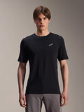 Alpinestars A-Dura Dri Wool Kurzarmtrikot, Schwarz, getragen von männlichem Model, kleines weißes Alpinestars-Logo auf der Brust, Performance-Radbekleidung für MTB-Trailfahrten, feuchtigkeitsableitendes drirelease-Wollgewebe