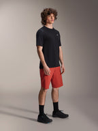 Male model wearing Alpinestars A-Dura Elite Shorts in Dark Orange and A-Dura Dri Wool Short Sleeve Jersey in Black, mountain bike performance gear, paired with black socks and shoes, athletic design for off-road cycling.