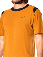 Alpinestars A-Dura Dri Wool Trikot, kurzärmeliges Radsport-Trikot, Dark Gold, schwarzer Mesh-Kragen und Schultereinsätze, kleines schwarzes Brustlogo, Nahaufnahme der Vorderansicht