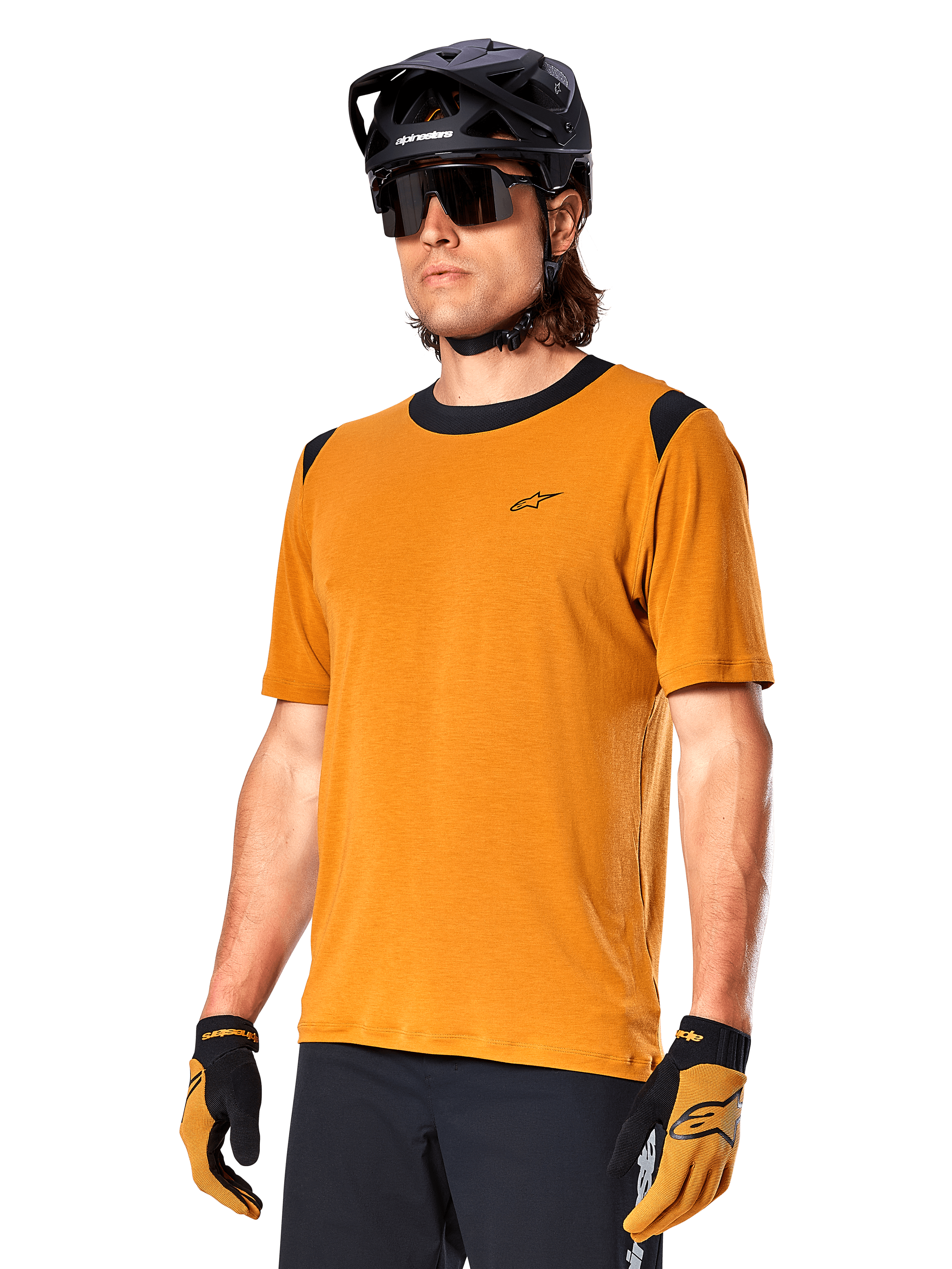 Alpinestars A-Dura Dri Wool Kurzarmtrikot, MTB-Radtrikot, Dunkelgold mit schwarzen Akzenten, technisches Kurzarm-Shirt aus Wollmischgewebe mit schwarzen Schultereinsätzen, getragen mit schwarzem Mountainbike-Helm und passenden Handschuhen