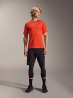 Alpinestars A-Aria Astar Kurzarmtrikot, Spicy Orange, getragen von einem Model mit schwarzen Mountainbike-Shorts und Knieschützern, leichte und atmungsaktive Performance-Radsportbekleidung für MTB