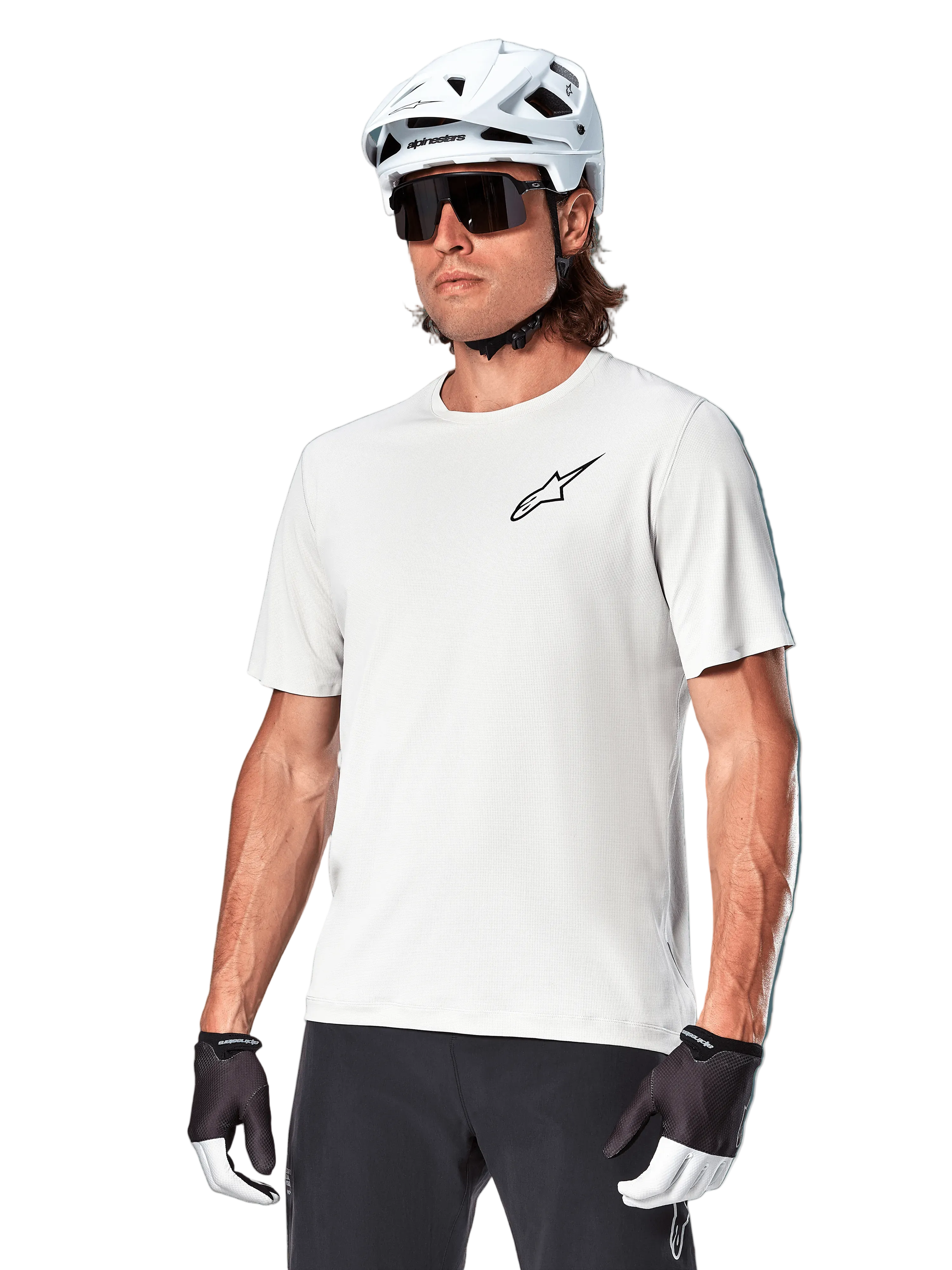 Alpinestars A-Aria Astar Kurzarmtrikot, White Dove, getragen von einem Radfahrer mit weißem Helm und dunkler Sonnenbrille, mit kleinem schwarzem Stern-Logo auf der Brust, atmungsaktive Performance-Ausrüstung für Mountainbiking