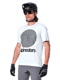 Alpinestars A-Dura Oscar Kurzarmtrikot, White Dove mit schwarzer Heritage-Spiralgrafik und Logo, getragen mit schwarzem MTB-Helm und Handschuhen, sportliche Performance-Mountainbike-Bekleidung
