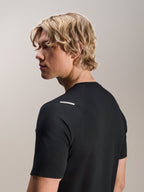 Mann im Alpinestars A-Aria Switch Kurzarmtrikot, Schwarz, Seiten- und Rückansicht zeigt die Performance-Passform und das Schulterdetail, leichte, atmungsaktive MTB-Radbekleidung