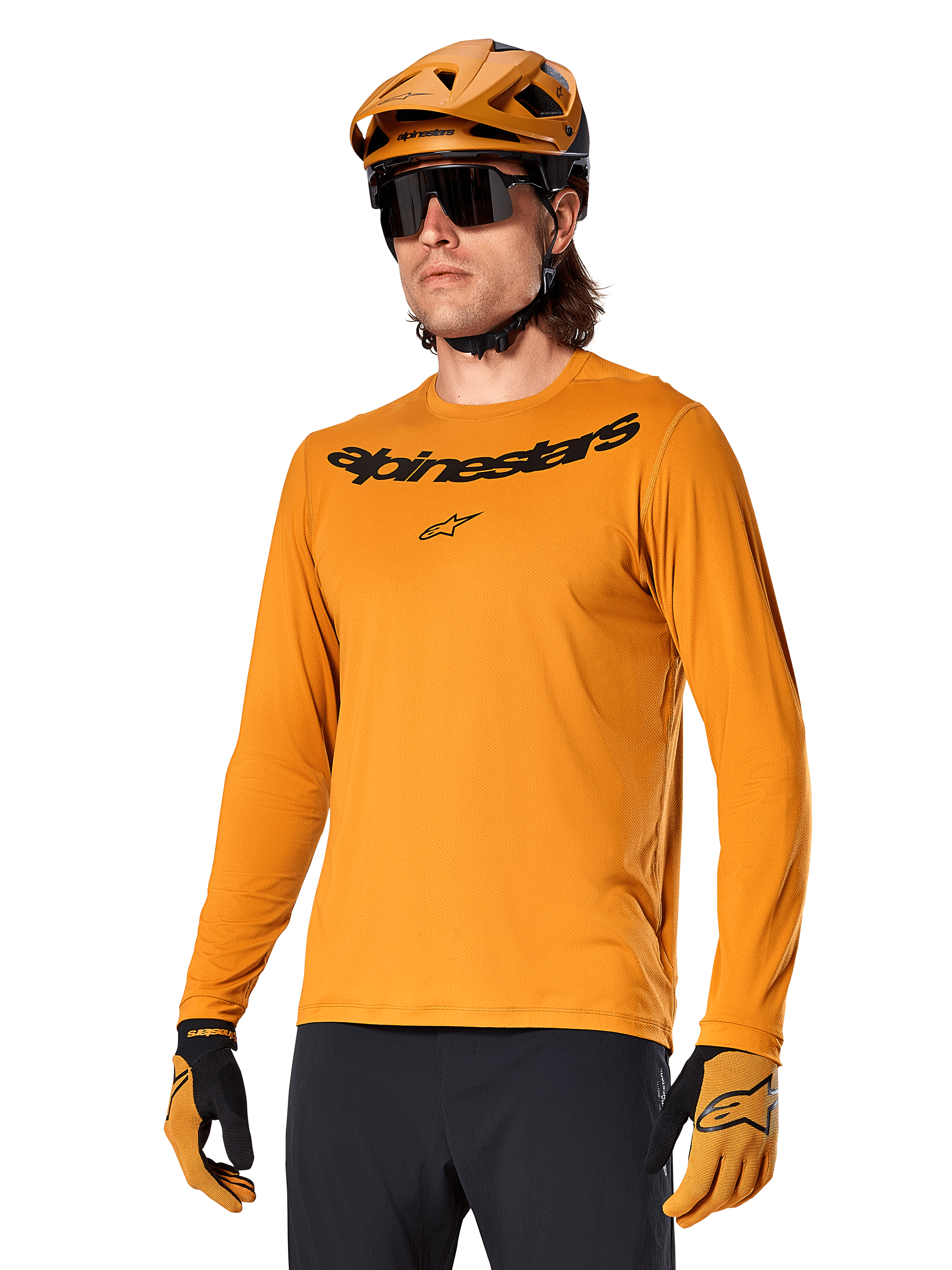 Alpinestars A-Dura Rocker Langarmtrikot, MTB-Mountainbike-Trikot, Dunkelgold, Person trägt Trikot mit passendem Helm und Handschuhen, sportlich abgestimmter Look mit Alpinestars-Wortmarke auf der Brust