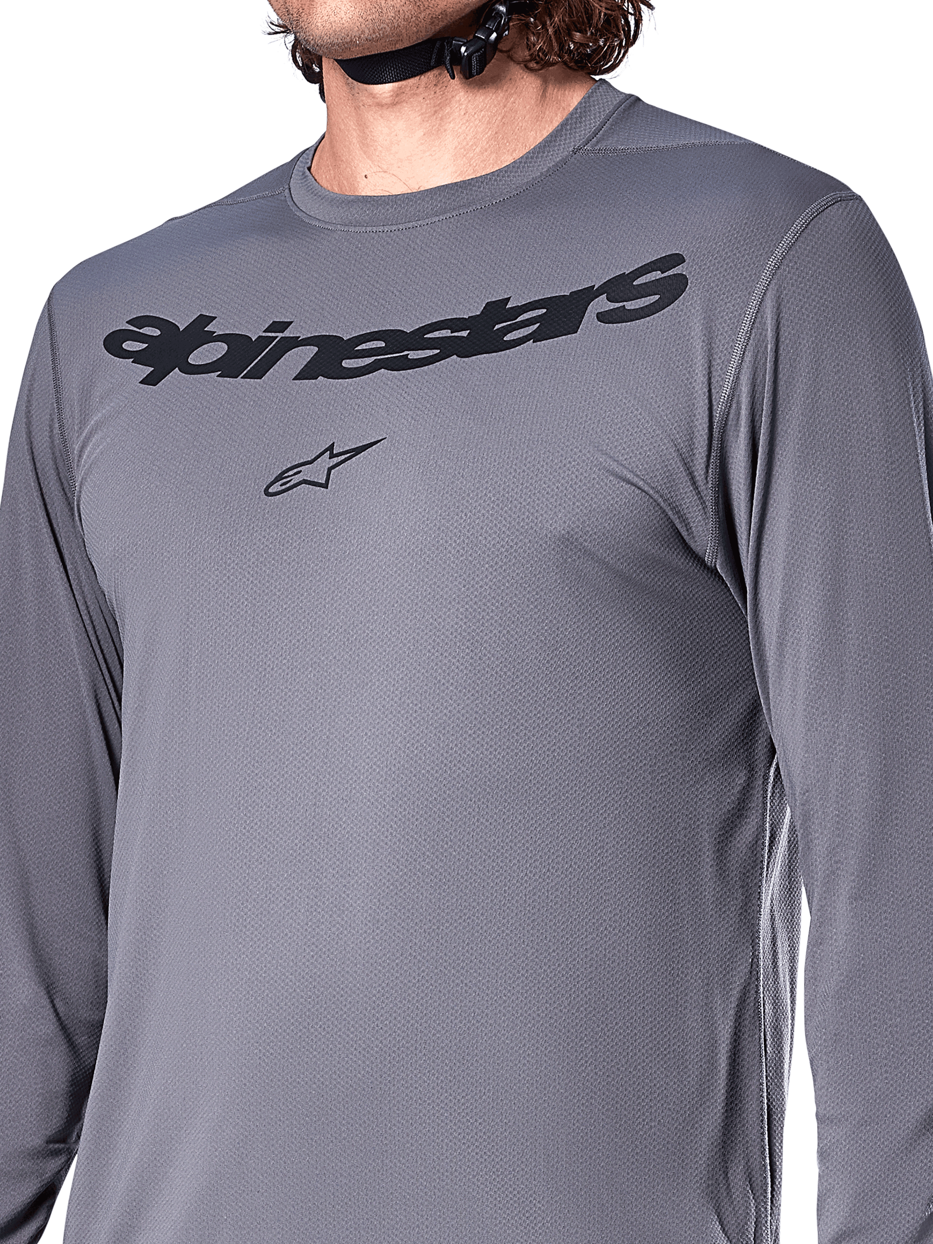 Alpinestars A-Dura Rocker Langarmtrikot, Dunkelgrau, Nahaufnahme der Brust mit schwarzem Alpinestars-Schriftzug und Stern-Logo, Jacquard-Poly-Spandex-Material, Performance-Mountainbike-Bekleidung