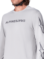 Alpinestars A-Dura Switch Jersey – Langarm, hellgraues Mountainbike-Trikot mit dunkelgrauem Schriftzug auf der Brust und Stern-Logo auf dem Ärmel, atmungsaktive Jacquard-Struktur, Performance-Radsportbekleidung für Trailfahrten