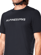 Alpinestars A-Dura Switch Kurzarmtrikot, Schwarz, mit einem großen weißen Wortmarken-Siebdruck-Logo auf der Brust, Performance-Jacquard-Gewebestruktur, Nahaufnahme der Vorderansicht