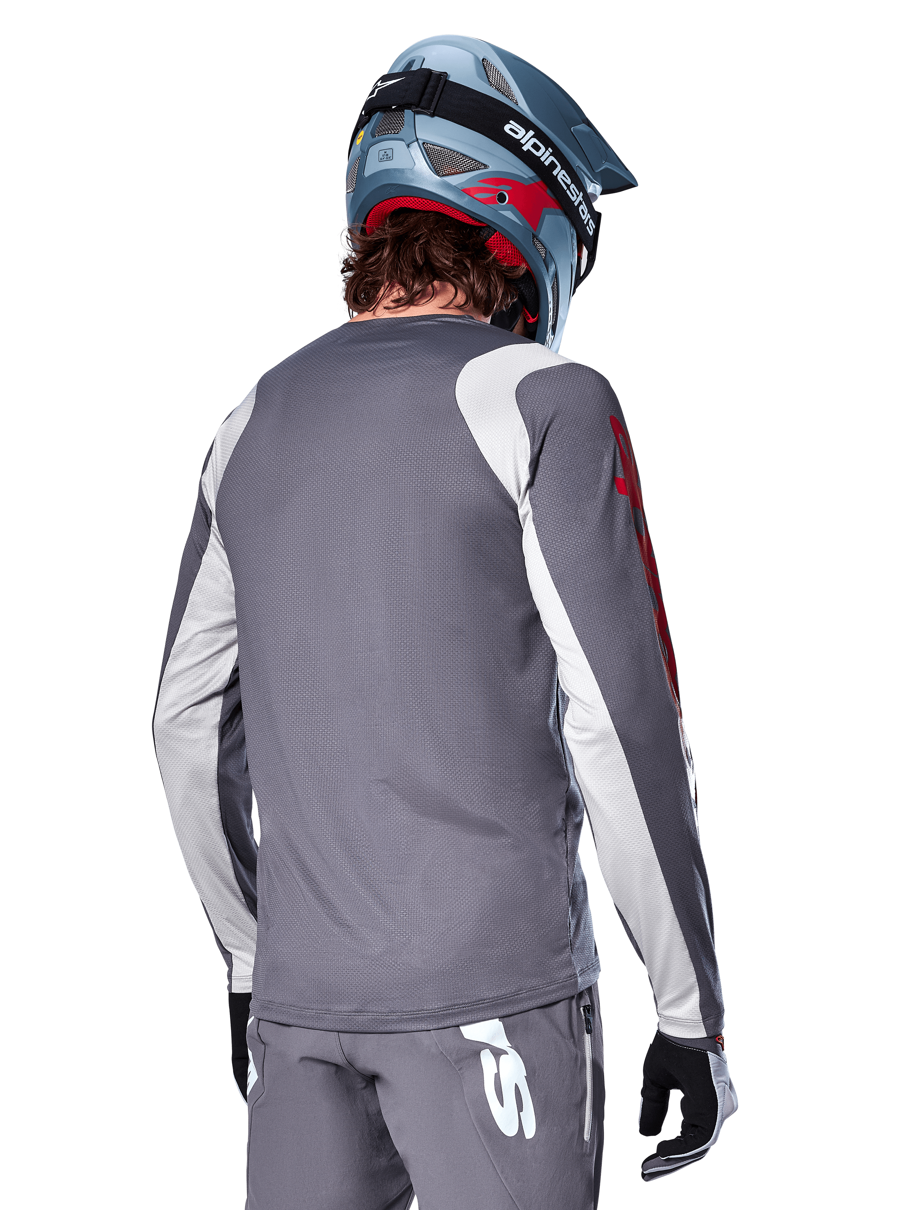 Alpinestars A-Supra Astar Langarmtrikot, Dunkelgrau mit hellgrauen Schulter- und Arm-Einsätzen, Rückansicht eines Fahrers mit blauem Fullface-Mountainbike-Helm und grauer Hose, MTB-Bekleidung mit Performance-Passform