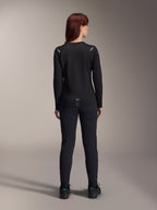 Alpinestars Damen Stella A-Dura Thermo-Trikot, Rückansicht, Schwarz, langärmliges Radtrikot mit isoliertem Fleece, getragen mit passender schwarzer Hose und Schuhen, mit kleinem A-Dura-Branding am unteren Rücken und reflektierenden Akzenten an den Schultern, speziell für Mountainbike-Fahrten von Frauen entwickelt.