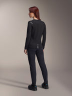 Alpinestars Damen Stella A-Dura Thermo-Trikot, langärmliges MTB-Trikot in Schwarz, Rückansicht mit reflektierenden Schulterakzenten und verlängertem Rückenteil, getragen mit schwarzer Hose und Schuhen, Performance-Ausrüstung fürs Mountainbiking