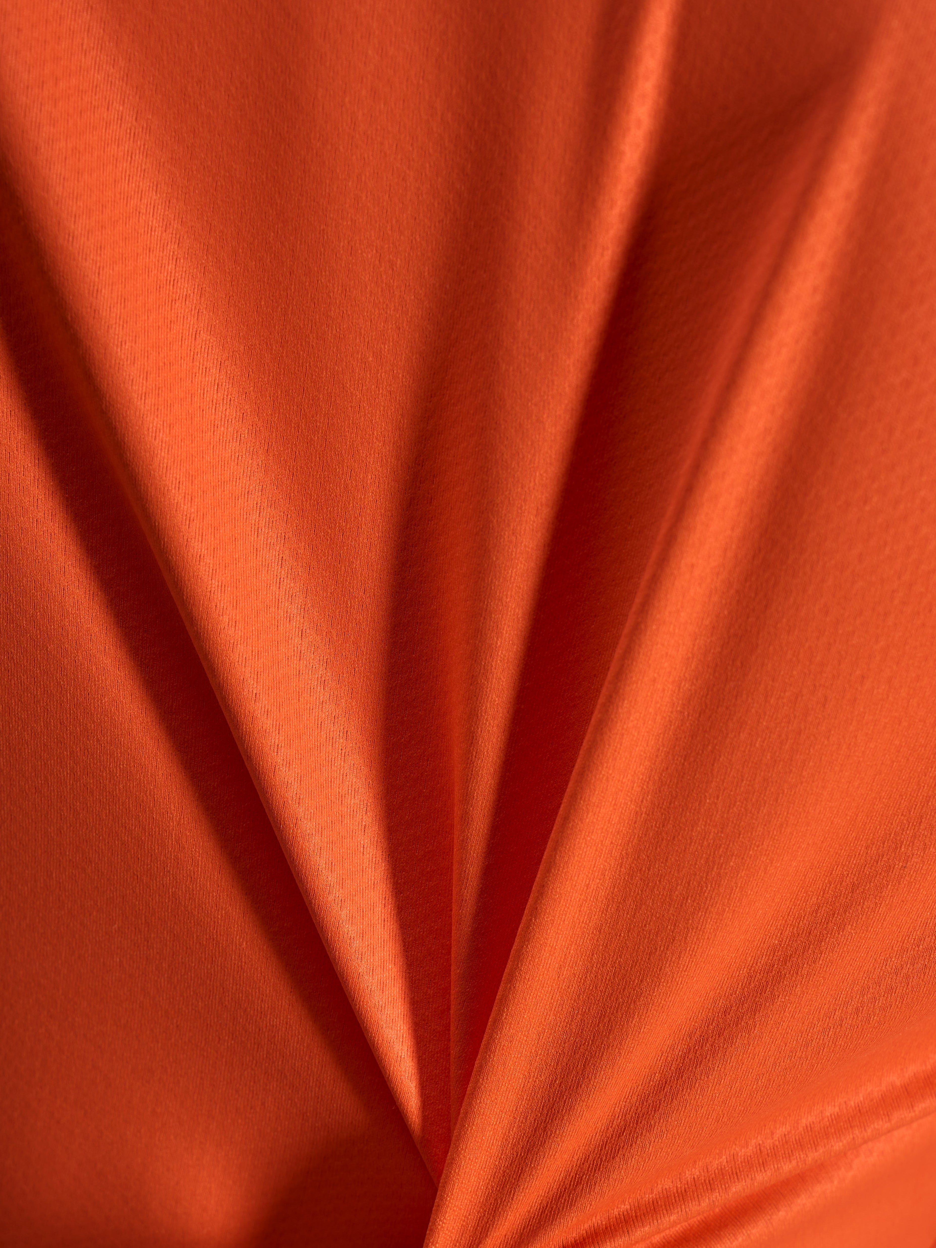 Oranges Jacquard-Stoffdetail des Alpinestars Stella A-Dura Ride Trikots mit leichter und dehnbarer Textur.