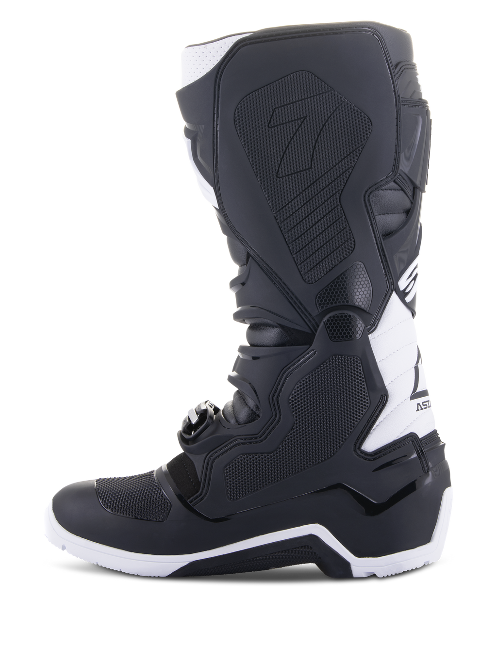 Alpinestars Tech 7 Enduro Drystar® Stiefel, Enduro-Motorradstiefel, Schwarz und Weiß, mediale Seitenansicht mit wabenförmig strukturierten Grip-Panels, TPU-Konstruktion und weißen Akzenten an Ferse und oberem Wadenbereich, professionelles Offroad-Schuhwerk